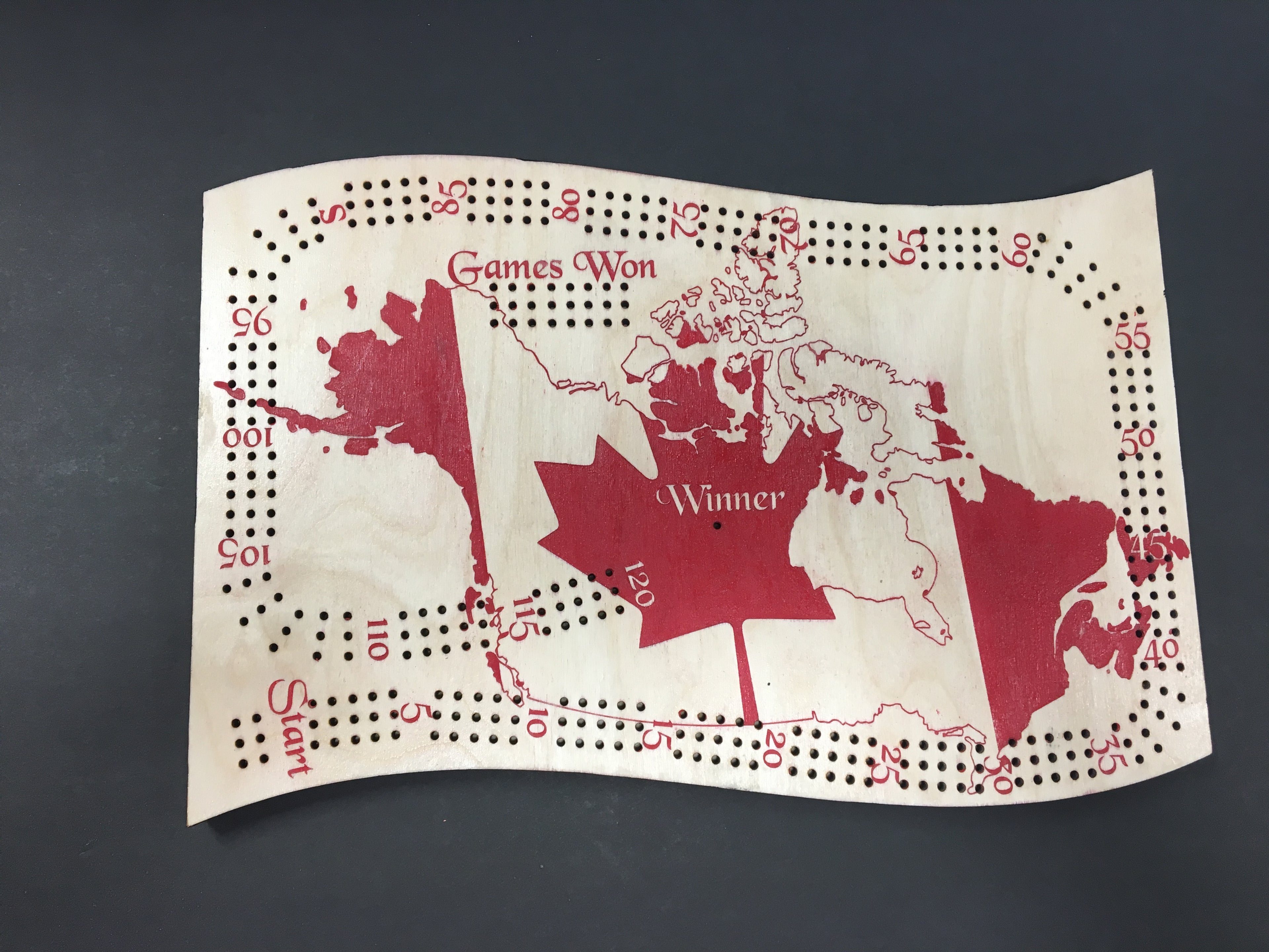 Cribbage board with a map of Canada design on a dark background