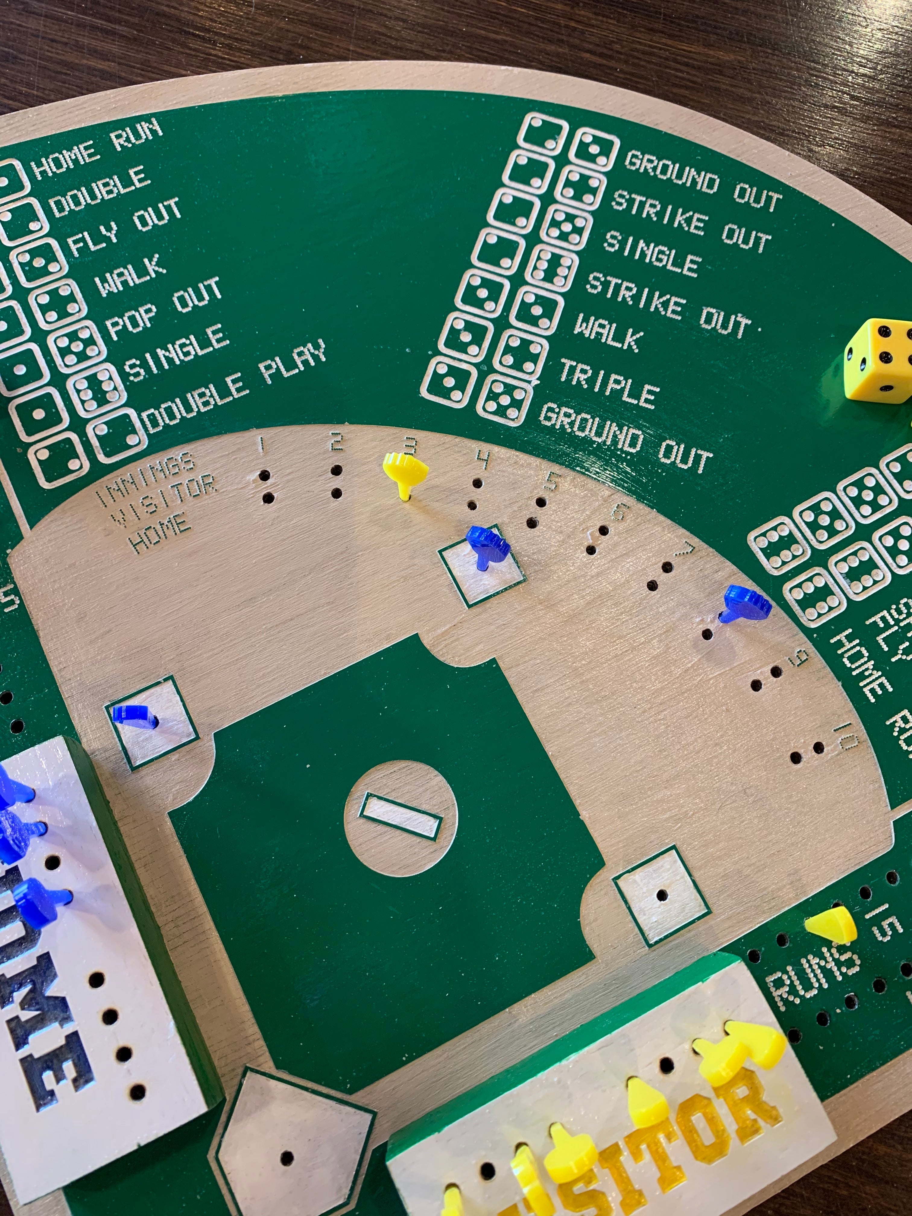 Baseball game board with dice and markers on a wooden surface
