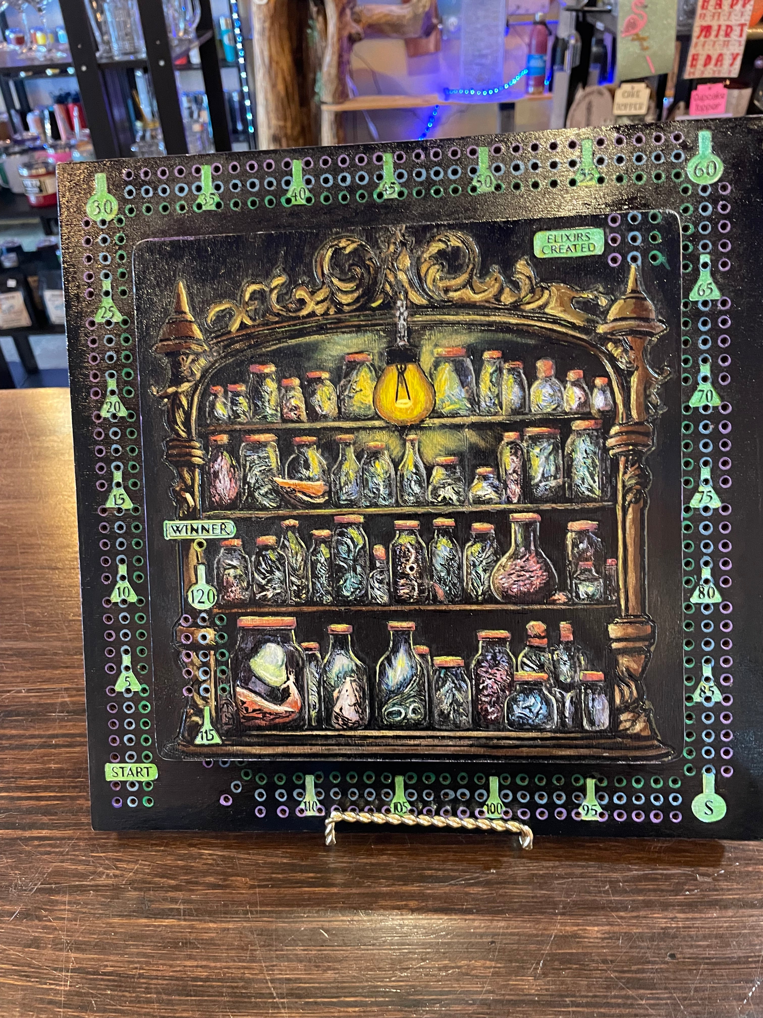 Decorative crib board with various potion bottles in a cabinet.