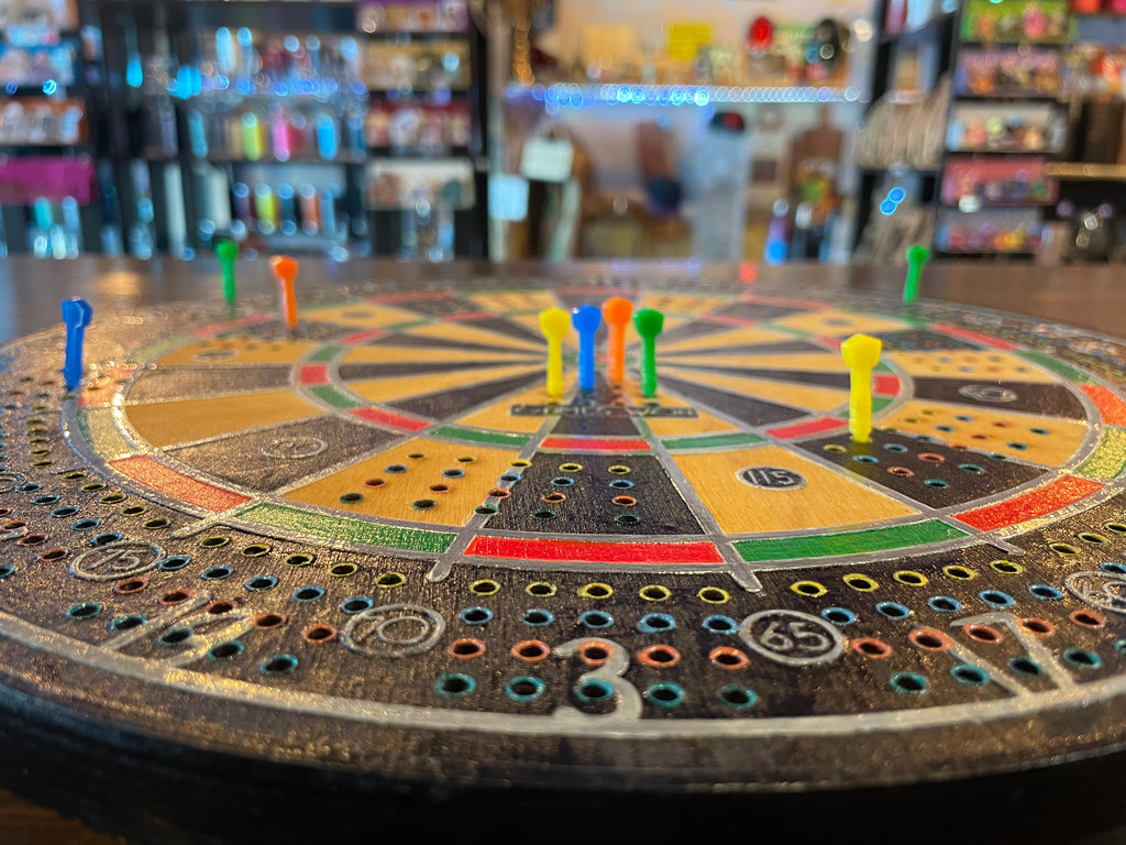 Closeup of a colorful dart board cribbage game with dart pegs.