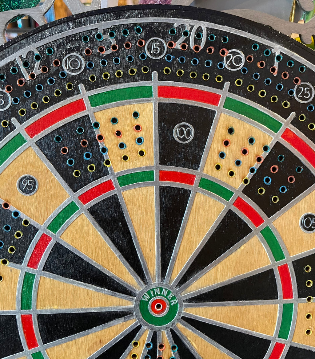 Close-up of a wooden dartboard with colorful scoring areas