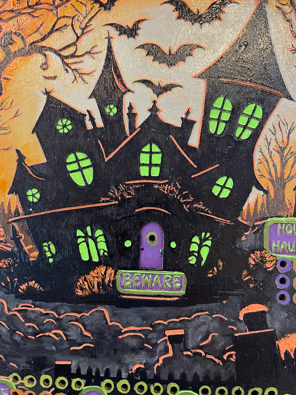 Halloween-themed decorative board with bats and a haunted house.
