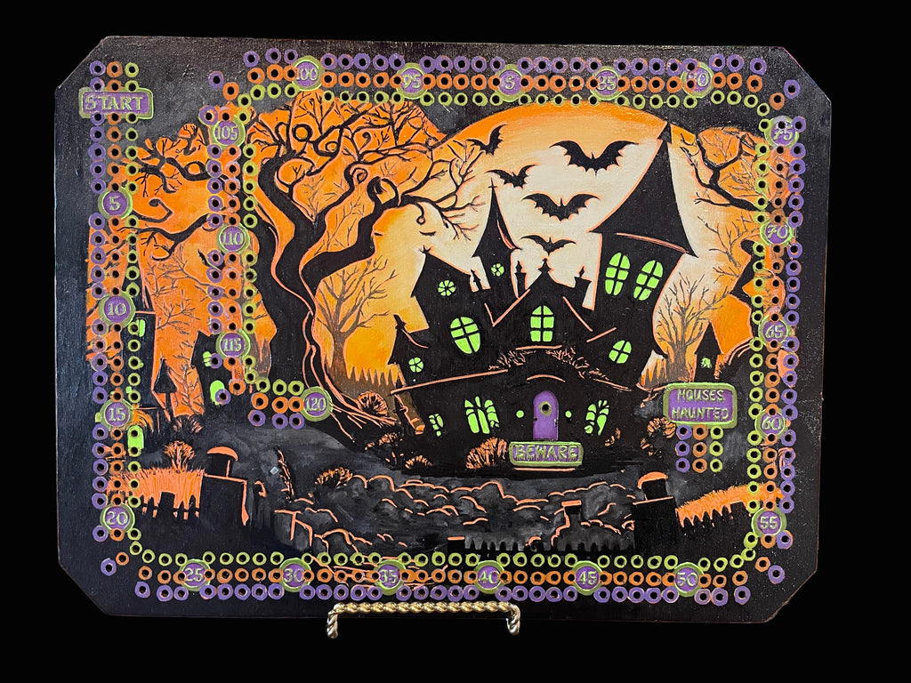 Halloween-themed decorative board with bats and a haunted house.