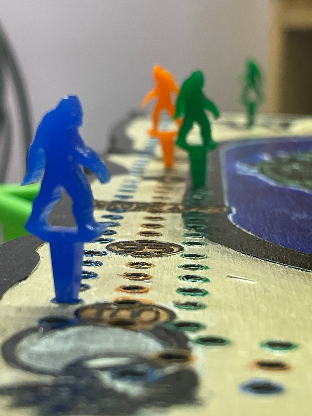 Close-up of colorful acrylic pegs on a cribbage board.