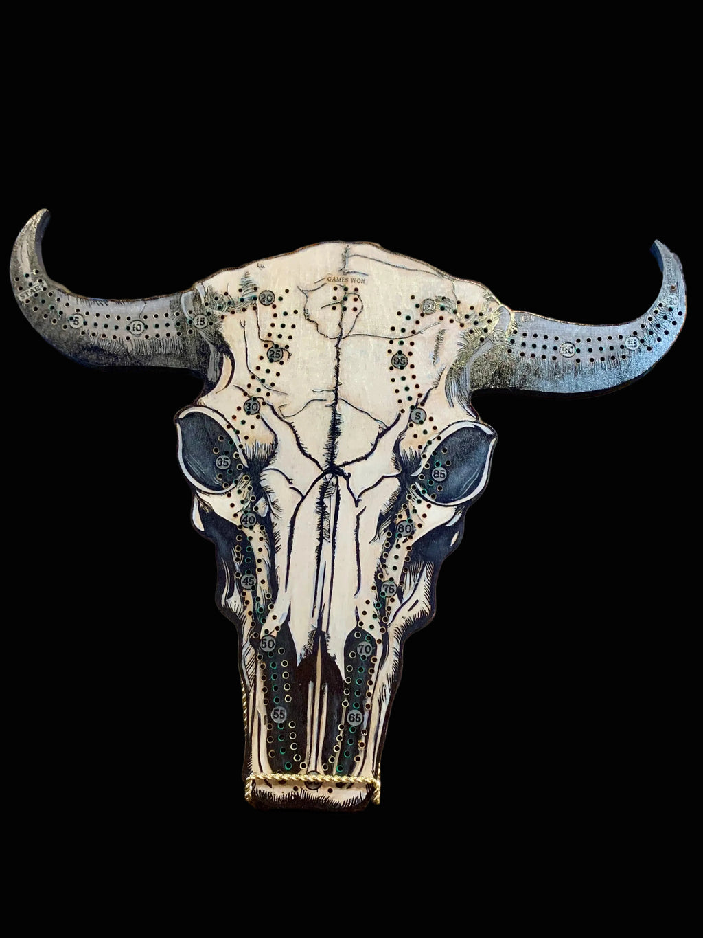 Decorative cow skull with artistic designs on a wooded crib board.