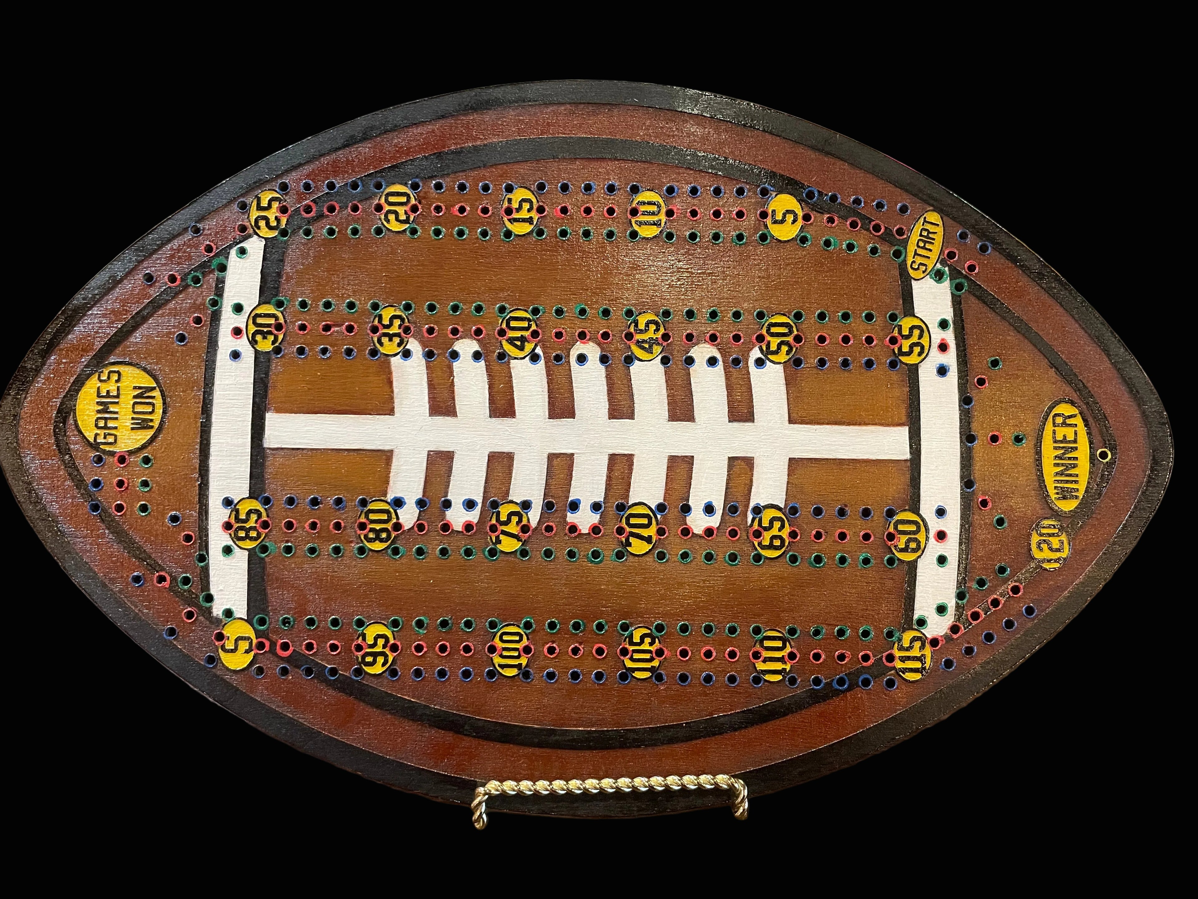 Wooden cribbage board shaped like a football.