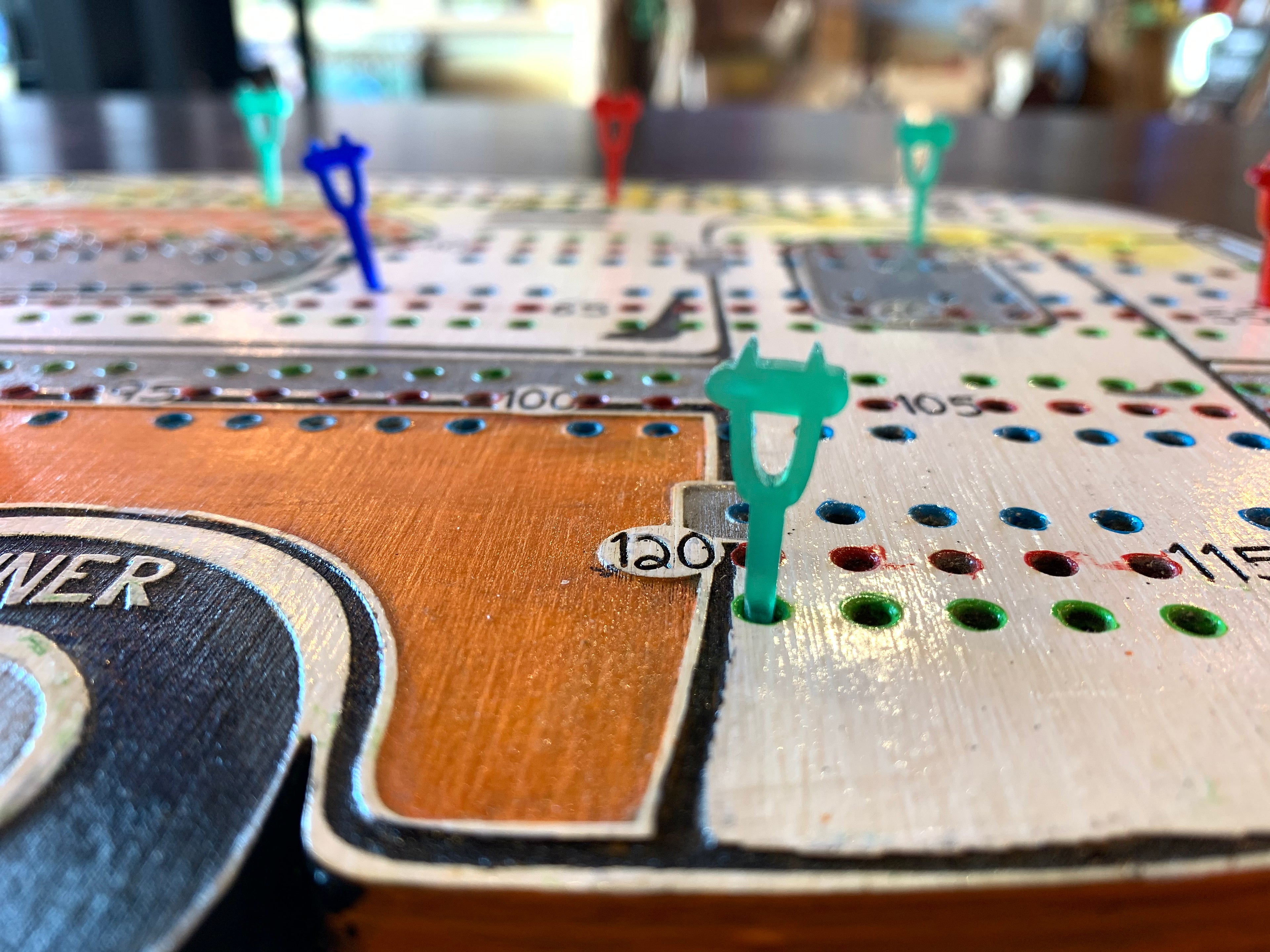 Close-up of a crib board game with acrylic pegs.